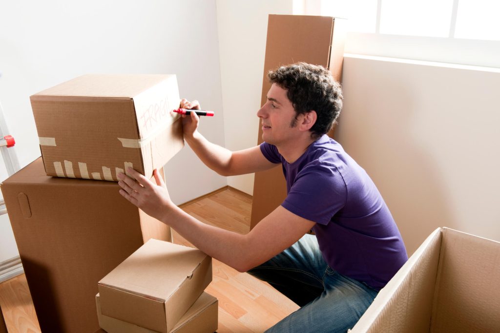 A man labeling boxes and needing Professional Packing Services
