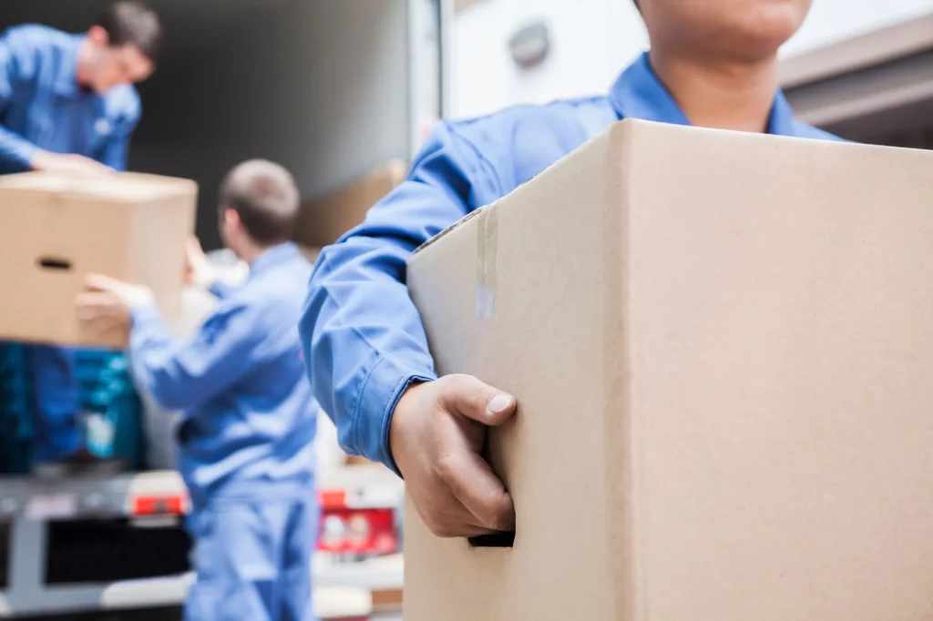 Moving crew loading cardboard boxes into a truck on moving day – Movers in Kansas City, MO