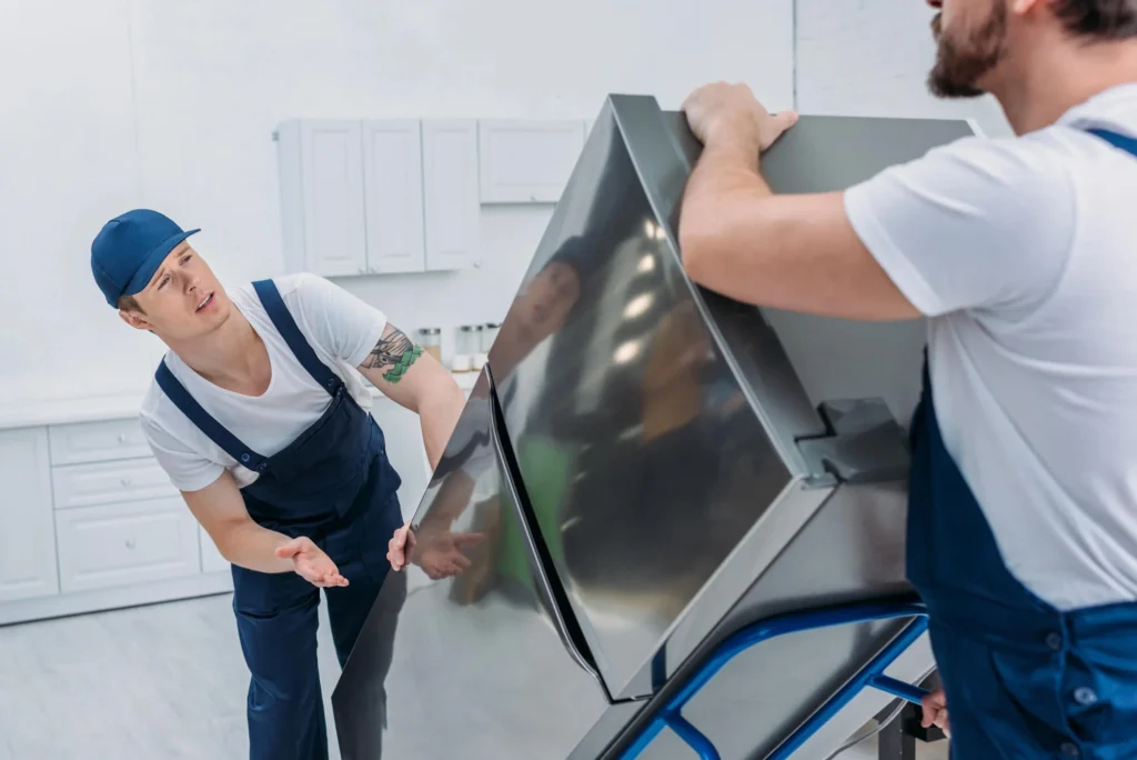 Professional movers lifting a heavy refrigerator with equipment for safe transport – Movers in Florence, KY