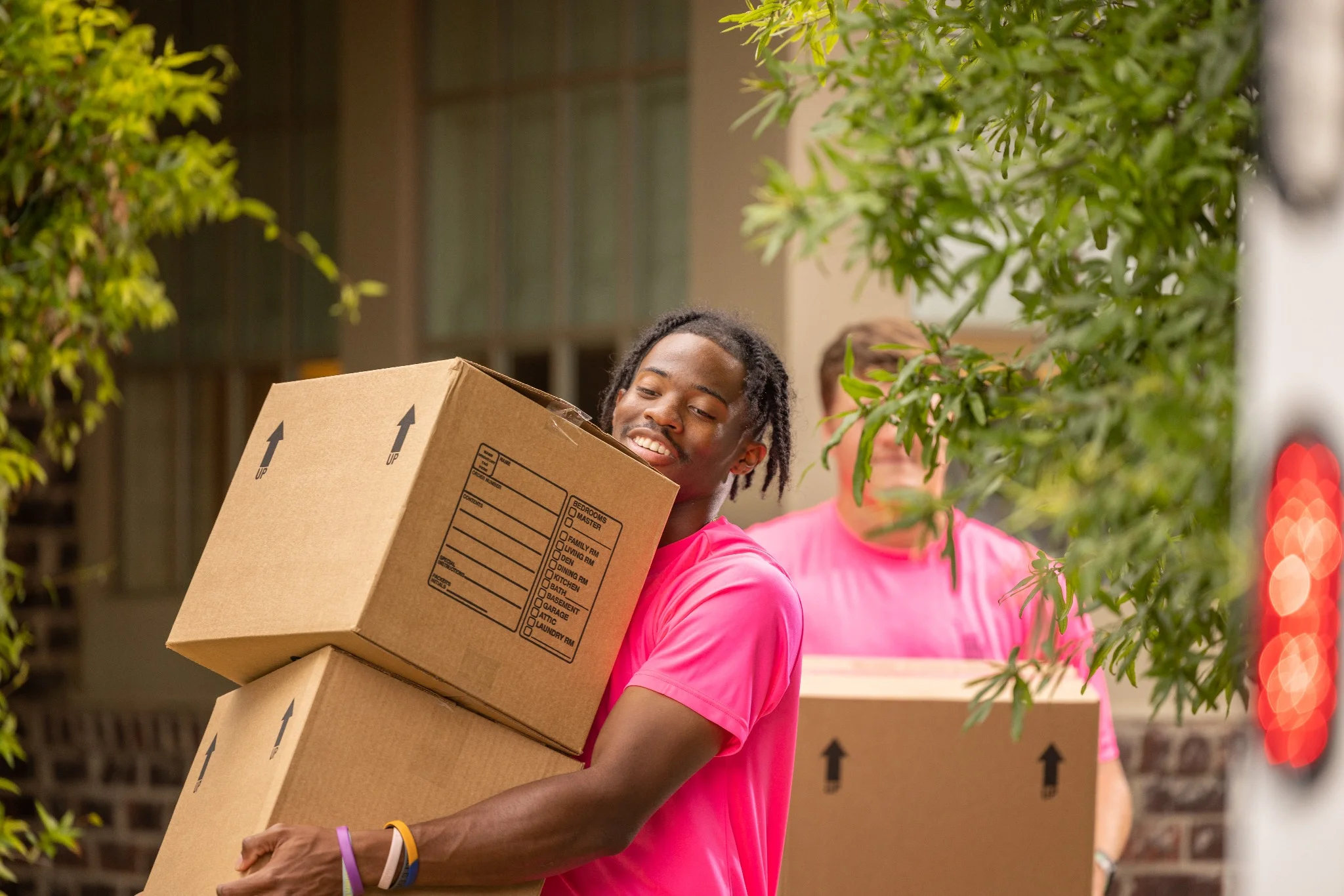 movers in huntsville al carrying boxes from a pink zebra moving truck