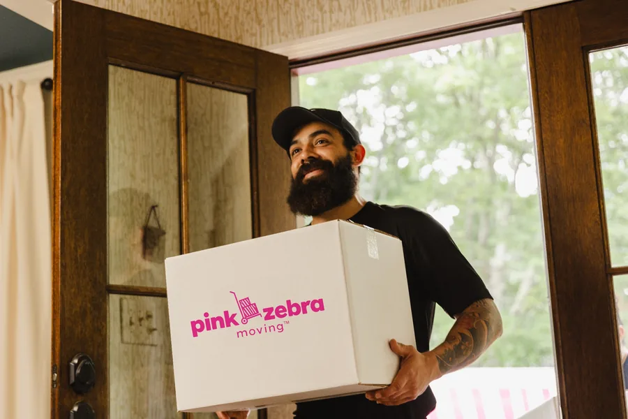professional mover carrying a moving box into a office in plano tx